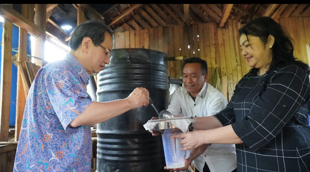 Petani serai wangi binaan Yayasan Dharma Bhakti Astra (YDBA), Adang Sabroni (tengah) mendampingi Ketua Pengurus YDBA Sigit P. Kumala (kiri) dan Sekretaris Pengurus YDBA, Ida R. M. Sigalingging (kanan) saat melakukan penyaringan minyak atsiri seusai peresmian Lembaga Pengembangan Bisnis (LPB) YDBA di Lebak, Banten, Rabu (15/2/2023). dok. ist. Astra melalui YDBA Resmikan Lembaga Pengembangan Bisnis di Lebak, Banten