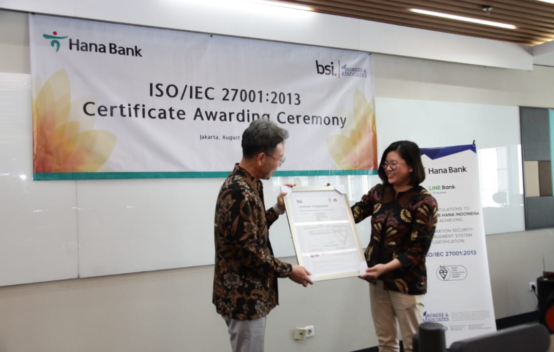 Bank Hana Raih Sertifikasi ISO/IEC 27001:2013, secara simbolis diterima oleh Direktur Utama Bank Hana Park Jong Jin dan diserahkan oleh Direktur Robere & Associates Indonesia Vera Anita sebagai partner dan perwakilan dari BSI, di Kantor Pusat Bank Hana, Jakarta,  pada Rabu (9/8/2023). dok. ist. Tingkatkan Standar Keamanan Sistem Informasi Bank Hana Raih Sertifikasi ISO/IEC 27001:2013