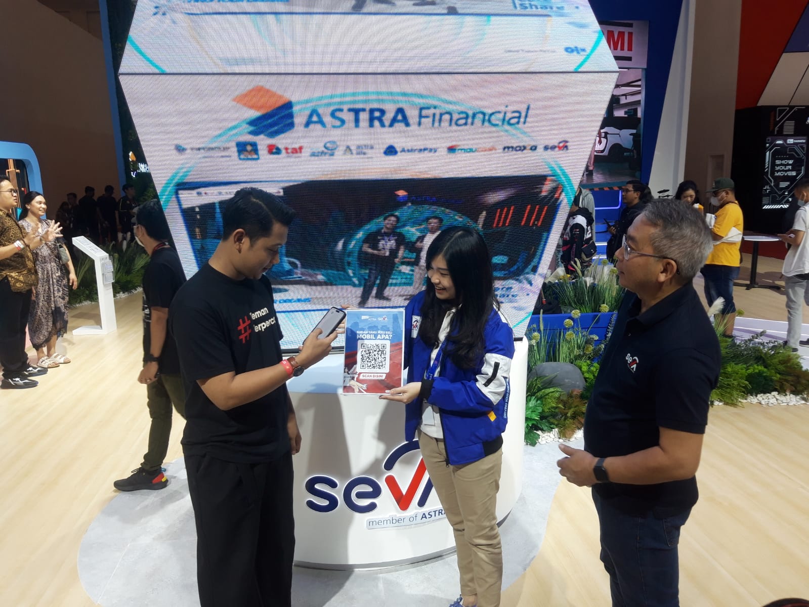 CEO SEVA, Handoko Liem (kanan) menyaksikan Tim Sales SEVA menawarkan promo menarik dari SEVA di GIIAS, yaitu Cashback 1 kali Angsuran maksimal senilai Rp4 juta, serta Bebas 1 Tahun Asuransi Comprehensive dari Garda Oto kepada konsumen yang hadir, Senin (14/8/2023). dok. ist. SEVA Tawarkan Promo Cashback dan Hadiah Asuransi di GIIAS 2023!