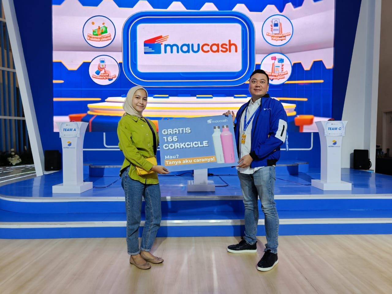 Chief Marketing Officer Maucash Indra Suryawan mendampingi tim Maucash menjelaskan promo Maucash selama GIIAS 2023 kepada salah seorang pengunjung. dok. ist. Maucash Berpartisipasi Aktif dalam GAIKINDO Indonesia International Auto Show 2023