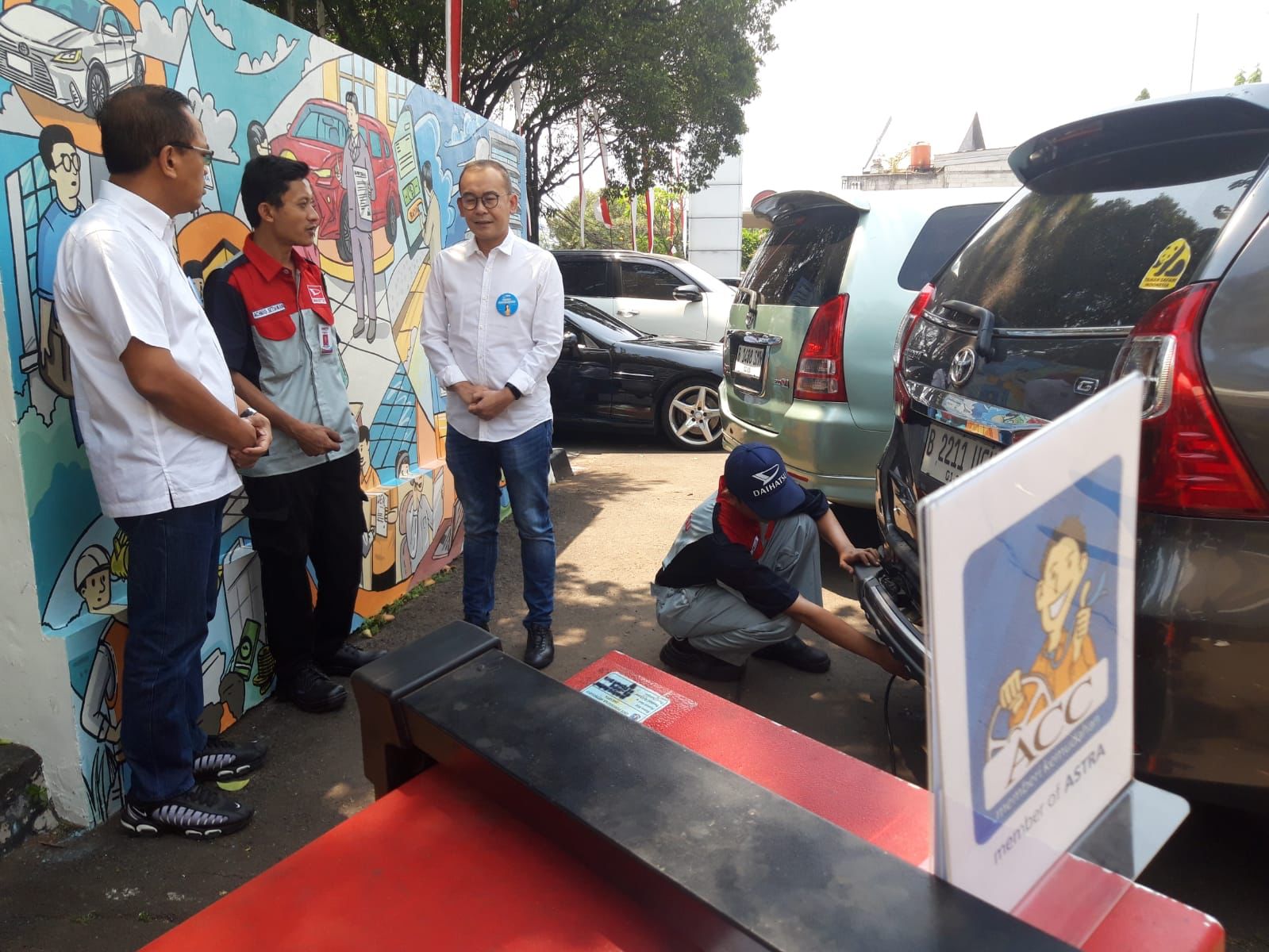 Chief Operation Officer ACC Devy Santoso Jayadi (kanan) didampingi oleh Retail Operation Division Head Agung Waluyo Samadi berbincang dengan petugas uji emisi. dok. ist. Astra Credit Companies Berikan Diskon Denda 45 Persen di Hari Pelanggan Nasional 2023