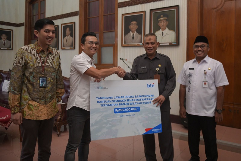 Direktur Risk Management BTN Setiyo Wibowo (kedua dari kiri) bersama Asisten Bidang Perekonomian Pembangunan Setda Kudus, Djatmiko Muhardi (kedua dari kanan) menyerahkan bantuan paket sembako kepada masyarakat terdampak banjir di Kudus, Jawa Tengah, Kamis (28/3). (Foto: Endang Muchtar) BTN (BBTN) Bantu Korban Banjir di Jawa Tengah