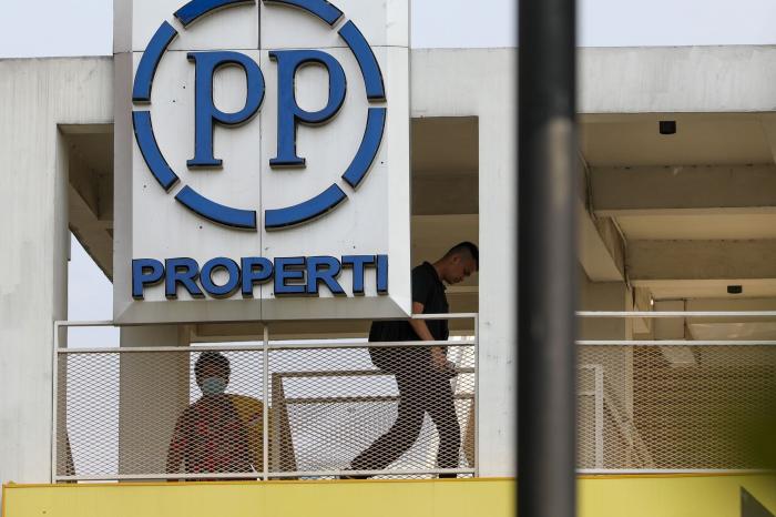 LINTAS - Seseorang tengah melintas pada sebuah jembatan penyeberangan dengan plakat PP Properti. FOTO - ISTIMEWA Ambrol 768 Persen, PP Properti (PPRO) 2023 Tekor Rp1,27 Triliun
