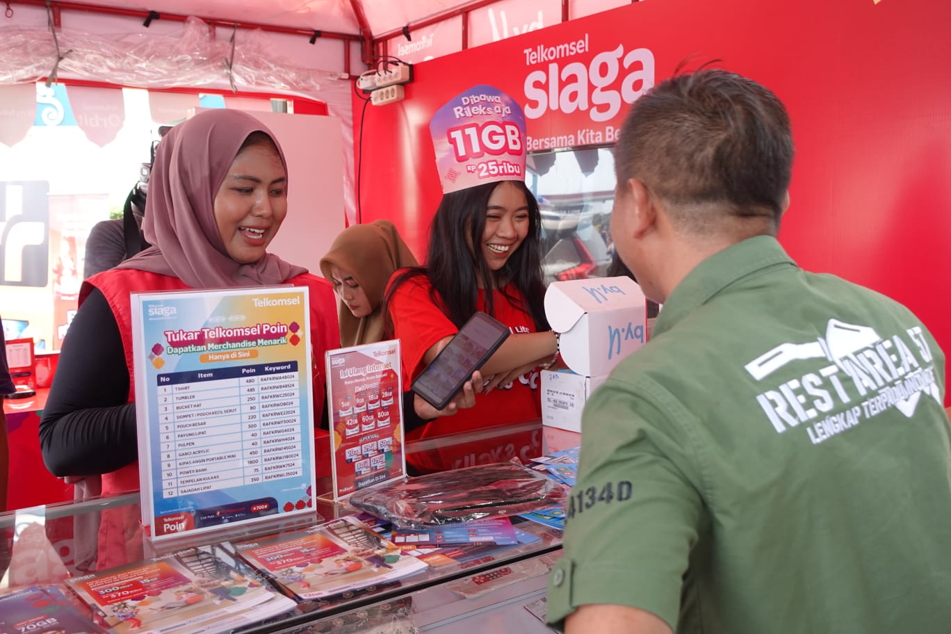 Karyawan melayani pelanggan di gerai posko Telkomsel Siaga, di Karawang, Jawa Barat, Sabtu (6/4/2024). Posko Telkomsel Siaga hadir di KM 57 Karawang Tol Jakarta-Cikampek dengan sederet promo spesial bagi pelanggan yang mudik ke kampung halaman.. (Foto: Endang Muchtar) Posko RAFI Telkomsel Siap Manjakan Pelanggan