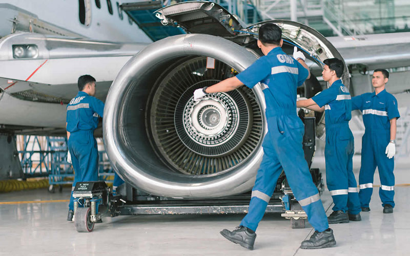 SERVICE - Teknisi GMF Aero Asia tengah memperbaiki mesin pesawat. FOTO - ISTIMEWA Laba Meroket 467 Persen, GMFI 2023 Akumulasi Kerugian USD583 Juta