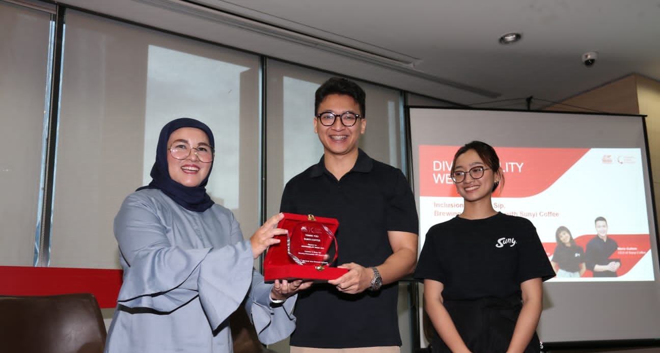 Manajemen Generali Indonesia, Vivin Arbianti Gautama selaku Chief Marketing and Partnership Distribution (kiri) memberikan cinderamata kepada Mario Gultom, CEO Sunyi Coffee (tengah), didampingi oleh Della, Deaf Barista (kanan) saat sesi talkshow interaktif dengan tema ‘Inclusion in Every Sip, Brewing DiversAbility with Sunyi Coffee’ pada Rabu (11/12/2024). Dok. Generali Indonesia. Dukung Teman Difabel Jadi Barista, Generali Indonesia Gaungkan DEI