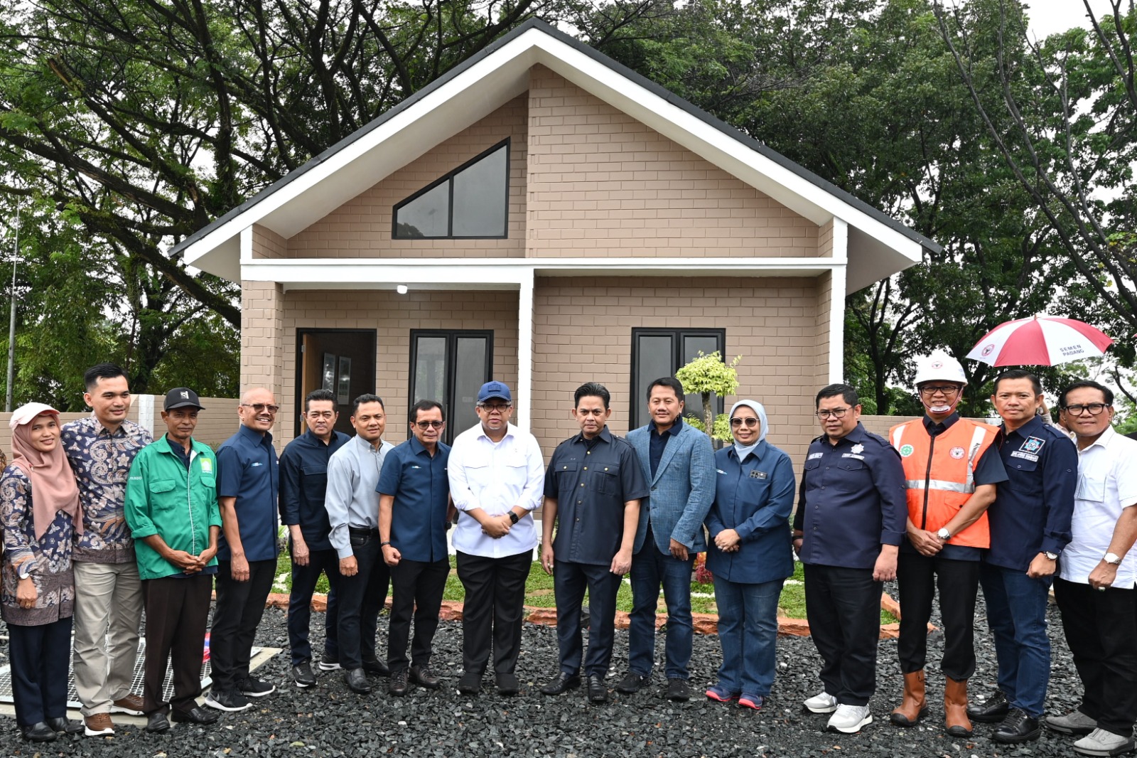 Wakil Menteri PKP, Fahri Hamzah (tengah) bersama Direktur Utama SIG, Donny Arsal (ketujuh kiri) saat mengunjungi unit contoh rumah MBR tipe 36 yang dibangun menggunakan produk turunan semen hijau SIG bata interlock presisi di Indarung, Padang, Sumatera Barat, Jumat (24/1/2025). dok. ist. Wujudkan 3 Juta Rumah, SIG Dorong Penggunaan Bata Interlock Presisi