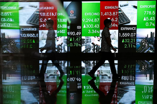 Seseorang berjalan berlatar layar gerakan IHSG. FOTO - ISTIMEWA Lanjutkan Tradisi Positif, IHSG Siap Langkahi 6.818