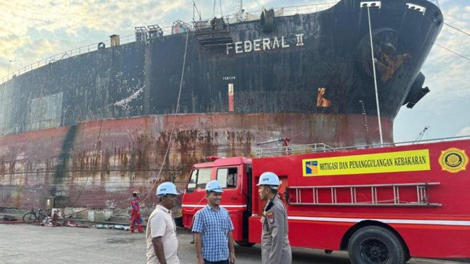 Sejumlah pekerja tengah beraktivitas di depan potret foto kapal milik SHIP. FOTO - ISTIMEWA SHIP Akui Kapal Anak Usaha Alami Kebakaran